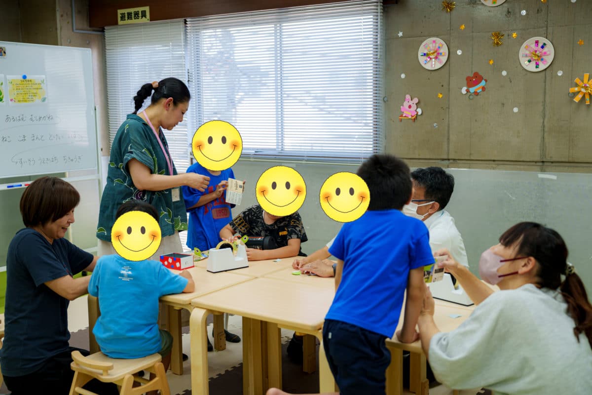 「発達障害の子どもたち一人ひとりに寄り添い、個別支援を行う横浜市南区『ひとつぼし』のスタッフが、子どもたちの集中力と巧緻性を引き出すために丁寧に声かけやサポートをする様子」